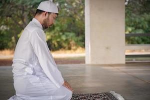 oración del hombre islámico asiático, oración musulmana joven, concepto del festival de ramadán foto