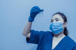 Asian doctor with Syringe and vaccine for protect covid-19 virus on white background photo