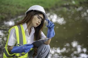 los ingenieros ambientales inspeccionan la calidad del agua, llevan el agua al laboratorio para su análisis, verifican el contenido de minerales en el agua y el suelo, verifican los contaminantes en las fuentes de agua. foto