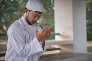 oración del hombre islámico asiático, oración musulmana joven, concepto del festival de ramadán foto