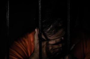 hombre asiático desesperado en la prisión de hierro, concepto de prisionero, gente tailandesa, esperanza de ser libre, prisioneros serios encarcelados en la prisión foto