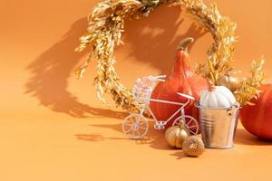 Autumn composition. Dried leaves wreath, pumpkins, on white orange background. Autumn fall ans thanksgiving day concept. Still life photo