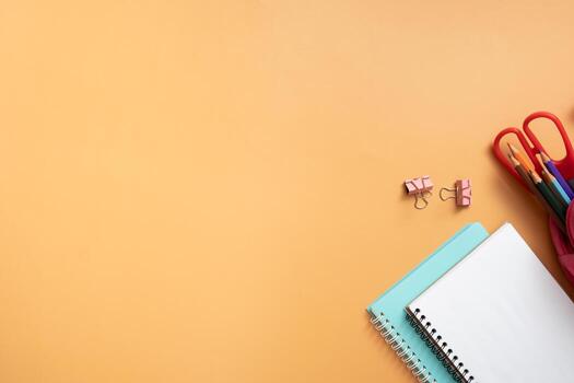 Notebooks and stationary on colored background. Copy space. Kids work space top view, flat lay. Online learning concept photo