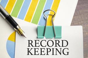 RECORD KEEPING words on notepad and charts photo