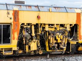 The ballast tamping machine is working to maintain the sleeper and ballast stone. photo