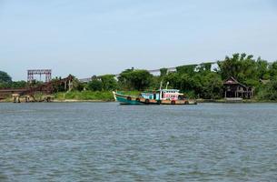 A tug boat is towing the large cargo boat which loaded the sand. photo