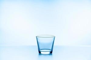 vidrio. vaso de agua sobre un fondo azul foto