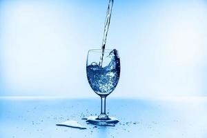 water splash collection in wine glass isolated on blue background photo
