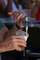 man pouring a draught beer with foam