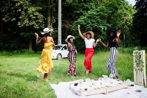 grupo de chicas afroamericanas celebrando la fiesta de cumpleaños divirtiéndose y bailando al aire libre con decoración. foto