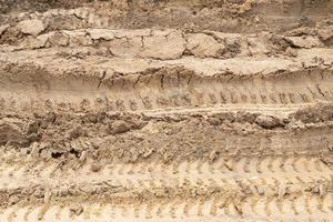 Beside view of liquid mud off road and there are marks of tires. photo