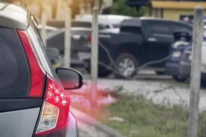 resumen y desenfoque del coche lateral trasero con luz de freno encendida y movimiento de luz roja. al lado de la carretera con estacionamiento y otros autos borrosos. foto