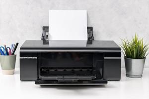 Inkjet printer with blank paper sheet on office desk. Template mock up photo