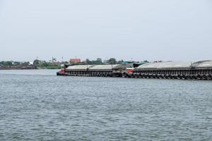 The large cargo boat is loading the sand  in the large river. photo