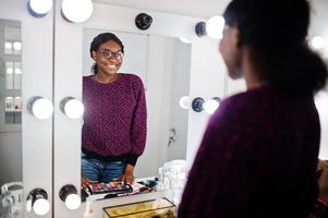 African American woman make-up artist at beauty saloon. photo