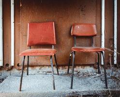 two red chairs in front of a wooden hut photo