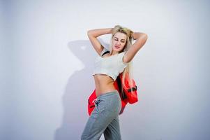 Chica rubia deportiva con una gran bolsa deportiva posada en el estudio con fondo blanco. foto