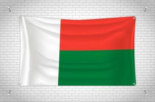 Madagascar flag hanging on brick wall. 3D drawing. Flag attached to the wall. Neatly drawing in groups on separate layers for easy editing. vector