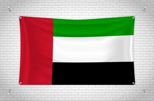 United Arab Emirates flag hanging on brick wall. 3D drawing. Flag attached to the wall. Neatly drawing in groups on separate layers for easy editing. vector