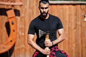 Arab hipster beard man lumberjack hold axe. photo