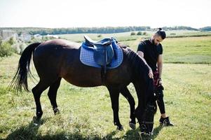 Arab tall beard man wear in black with arabian horse. photo