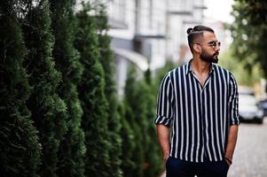 Successful arab man wear in striped shirt and sunglasses pose outdoor. photo