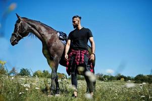 Arab tall beard man wear in black with arabian horse. photo