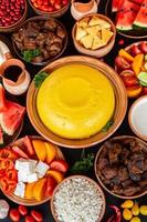 Homemade Romanian Food with polenta, meat, cheese and vegetables. Delicious corn porridge in clay dishes. Mamaliga or polenta, a traditional dish in Moldova, Hungary  and Ukrainian cuisine. photo