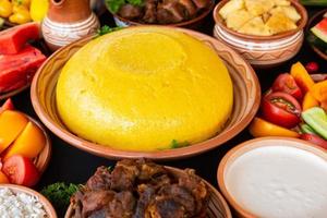 comida rumana casera con polenta, carne, queso y verduras. deliciosas gachas de maíz en platos de barro. mamaliga o polenta, un plato tradicional en moldavia, hungría y cocina ucraniana. foto