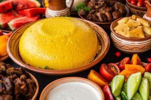 comida rumana casera con polenta, carne, queso y verduras. deliciosas gachas de maíz en platos de barro. mamaliga o polenta, un plato tradicional en moldavia, hungría y cocina ucraniana. foto