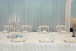 Empty banquet hall ready to receive guests on the summer terrace. white festive table photo