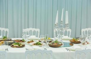 Empty banquet hall ready to receive guests on the summer terrace. white festive table photo