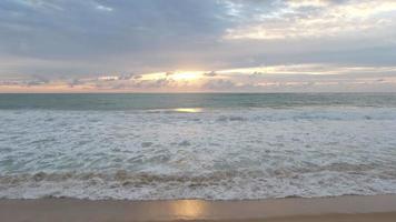 schöne meereswellen und weißer sandstrand auf der tropischen insel. schöne Aussicht auf die Sonnenuntergänge über dem Meer. Sonnenaufgang am Ozeanstrand und dramatische bunte Himmelswolken video