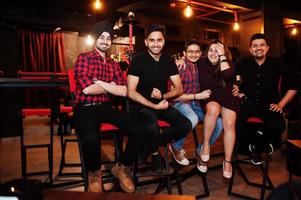 Group of indian friends sitting at lounge bar, having fun and rest. photo