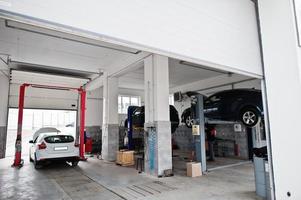 Cars lifting in maintenance at garage service station. photo