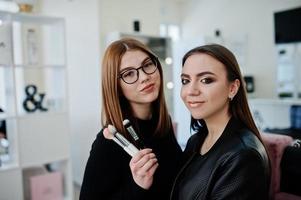 Make up artist work in her beauty visage studio salon. Woman applying by professional make up master. Beauty club concept. photo