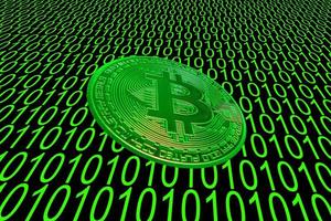 green binary code and a valueable green bitcoin from crypto currency oblique photo