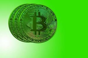 four green bitcoin from crypto currency during rising market on green back photo