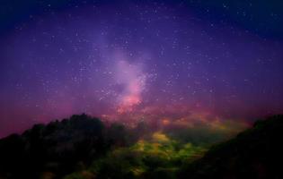 Milky Way and pink light at mountains. Night colorful landscape. Starry sky with hills at summer. Beautiful Universe. Space background with galaxy. Travel background photo