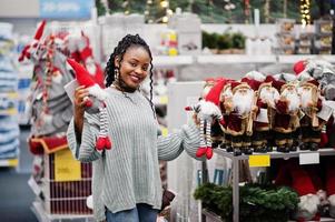 African woman choosing new year things for her apartment in a modern home furnishings store. Christmas theme shopping. photo