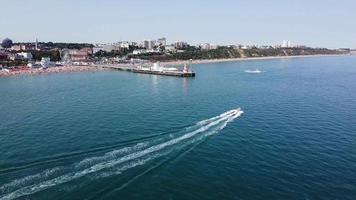 luchtfoto drone's beelden van snelle, race- en sportboten in de oceaan van Bournemouth Beach van Engeland Groot-Brittannië video