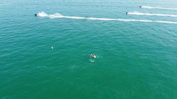 imagens de drones de visão aérea de barcos rápidos, de corrida e esportivos no oceano de bournemouth beach, na inglaterra, grã-bretanha video