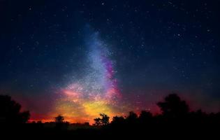 paisaje nocturno con colorida vía láctea y montañas. cielo estrellado con colinas en verano. hermoso universo. fondo del espacio foto