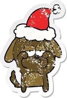 distressed sticker cartoon of a tired dog wearing santa hat vector