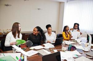 colegas mujeres multirraciales, equipo de divercity socias en el cargo se sientan a la mesa. foto