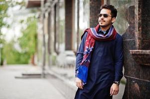 elegante hombre árabe musulmán indio paquistaní en traje kurta dhoti y gafas de sol. foto