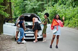 Group of five african american traveler girls looking at broken car open hood. photo