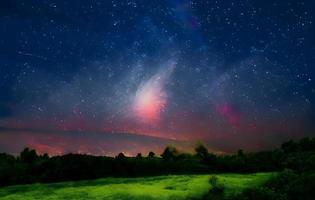 Milky Way and pink light at mountains. Night colorful landscape. Starry sky with hills at summer. Beautiful Universe. Space background with galaxy. Travel background photo