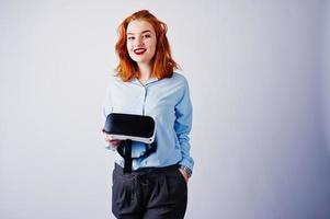 Red haired girl in blue blouse with vr glasses at studio isolated on white. photo