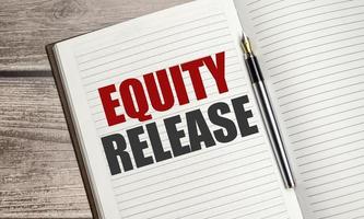 Equity Release words on brown diary on wooden background photo